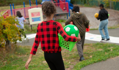 Kids playing outdoors are shown from behind.