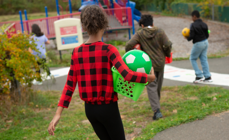 Kids playing outdoors are shown from behind.