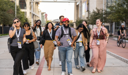 A group of event attendees walk together, smiling.