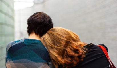 A woman lays her head on another's shoulder.